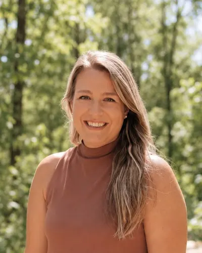 Sellina Faucher, souriante, photographiée à l’extérieur devant des arbres.